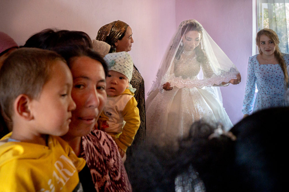 The bride stands with her head bowed, Capturing the Magic of a Rural Uzbekistan Wedding