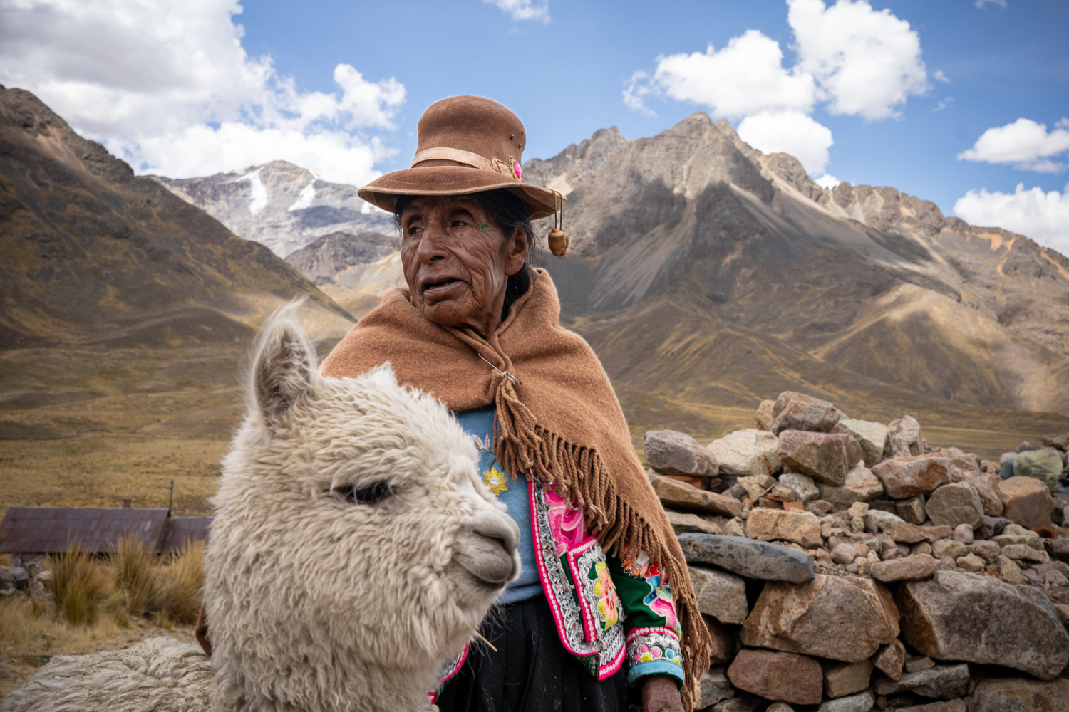 Local woman in traditional dress with a llama | Peru Photo Tour with raw.tours