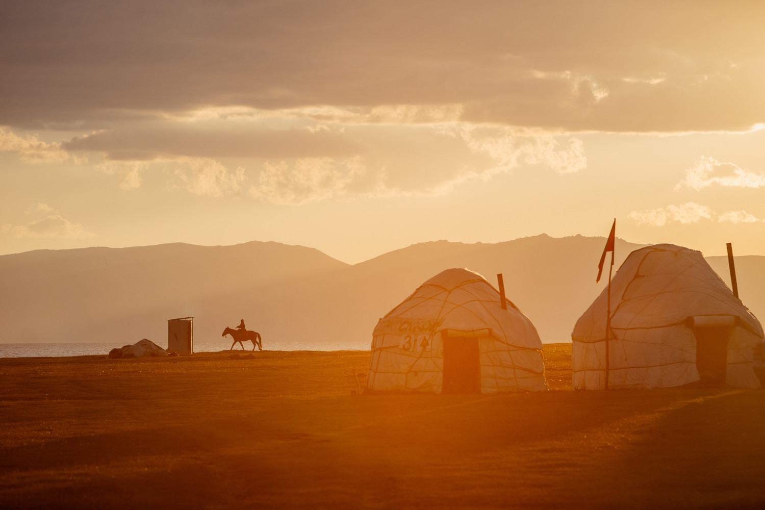 A man rides his horse as the sun sets in Kyrgyzstan.