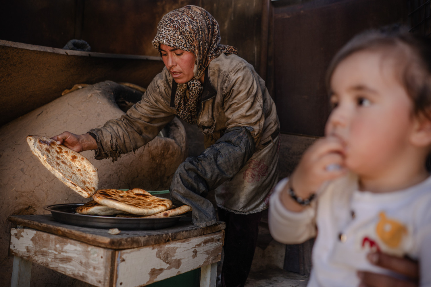 Woman baking bread in her family home, Uzbekistan