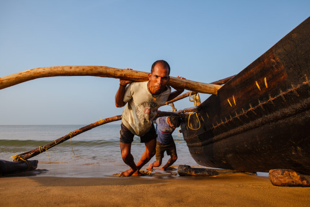 2 Men Pushing Their Boat Onshore - Tom Bourdon Travel Photography