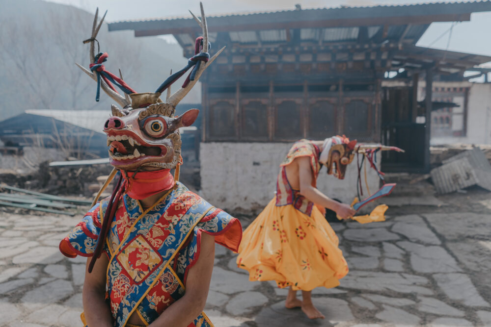 A masked dancer steps forward, while another practices behind him.
